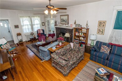 Living room featuring ceiling fan, a fireplace, an