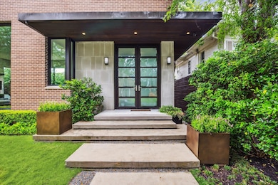 Ascend the concrete pavers to a grand covered entr