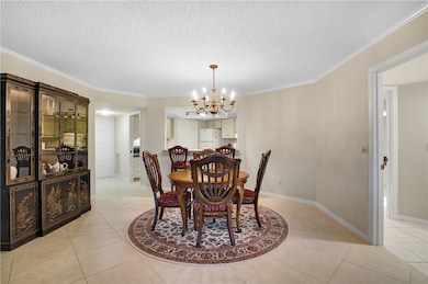 Dining space for hosting family, neighbors and guests. Condo tiled floors, ornamental molding and  chandelier.