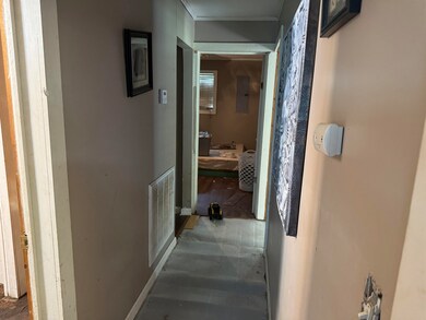 Hall with crown molding and electric panel