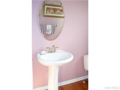 Bathroom Half bath off foyer features hardwood floors and lovely pedestal sink