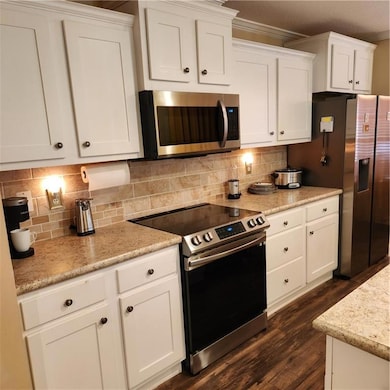 Kitchen featuring white cabinets, range with elect