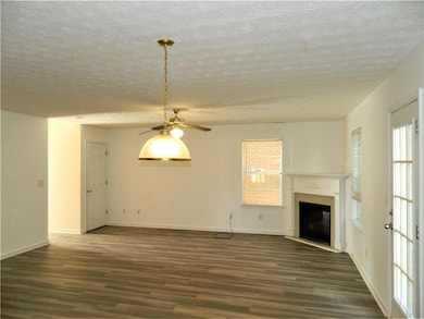 Unfurnished living room featuring ceiling fan, dar
