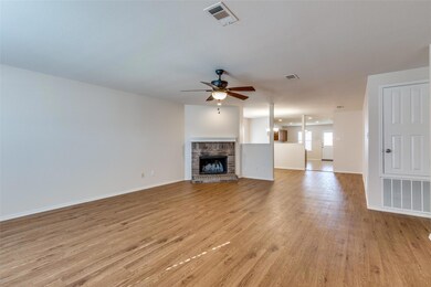 Living room with a brick fireplace, ceiling fan, a