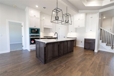 Kitchen featuring black microwave, oven, white cab