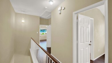 Corridor with attic access, an upstairs landing, and dark wood-style flooring
