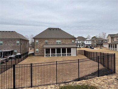 Rear view of property featuring a residential view, a fenced backyard, a shingled roof, and brick siding