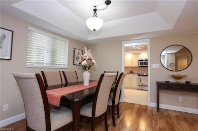Dining space with a raised ceiling, light wood-sty