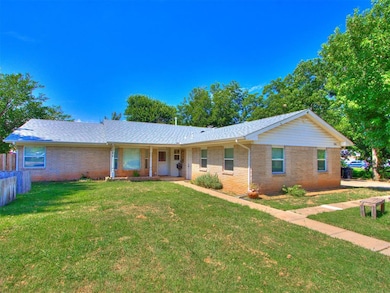 Ranch-style home with brick siding, covered porch, and a shingled roof