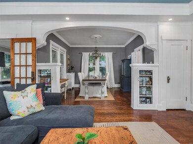 A graceful archway to the dining room, with pretty built-ins. Charcoal grey walls are enhanced by the crisp white millwork, doors and moldings.