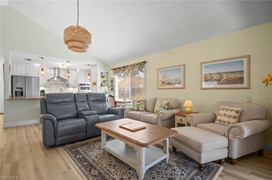 Living area featuring vaulted ceiling and light wood-style flooring