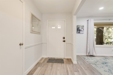 Foyer entrance with light wood-style flooring and recessed lighting
