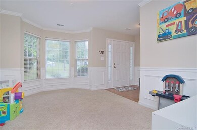 Dining room is currently being used as a playroom/office.  Bay window, picture-frame wainscoting, chair rail and crown molding.
