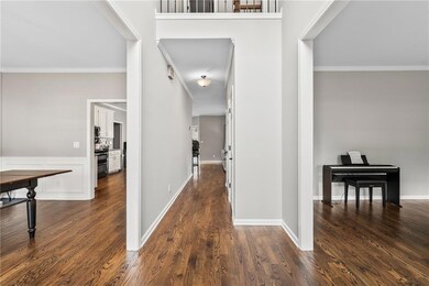Hallway with crown molding, dark wood finished floors, and baseboards
