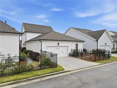 View of side of property with a shingled roof, driveway, and an attached garage