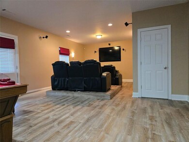 Finished basement with raised platform ideal for theater seating.