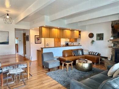 Living room with a fireplace, beam ceiling, and li