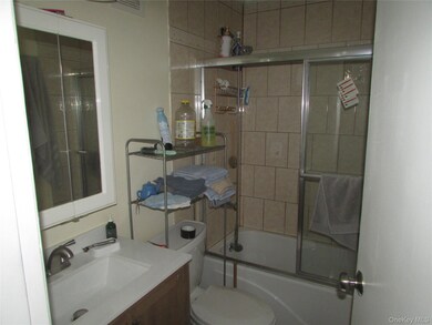 Bathroom with combined bath / shower with glass door and vanity