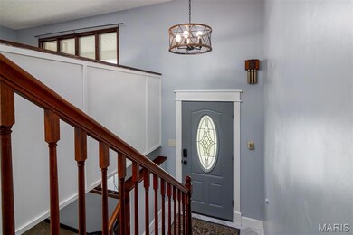 Foyer with a chandelier, stairs, and baseboards