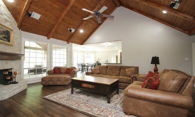 Vaulted wood ceiling plus stone Floor to ceiling fireplace! Wood floors! Built in entertainment center.