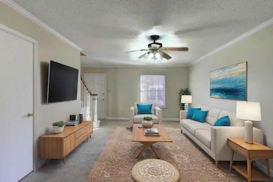 Carpeted living room with crown molding, a textured ceiling, ceiling fan, and stairway