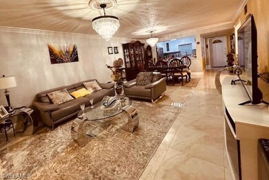 Living room with crown molding and a notable chand