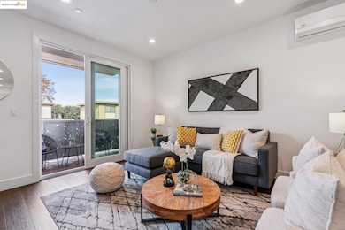 Living room featuring a wall mounted AC, wood finished floors, and recessed lighting