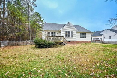 Back of property with a yard and a wooden deck
