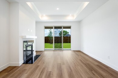 Unfurnished living room with a raised ceiling, a tile fireplace, wood finished floors, recessed lighting, and baseboards