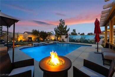 Pool at dusk with a patio, pool water feature, and