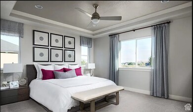 Bedroom featuring a raised ceiling, multiple windows, light carpet, ceiling fan, and a textured ceiling
