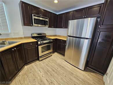 Kitchen with stainless steel appliances, light woo