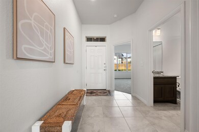 Entryway with light tile patterned floors and lig