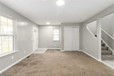 Entryway with light carpet and stairway