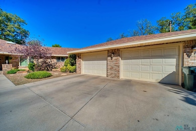 Single story home with driveway, brick siding, and roof with shingles