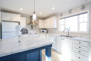 Kitchen with decorative light fixtures, sink, whit