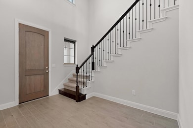 Foyer entrance with wood finished floors, stairs,