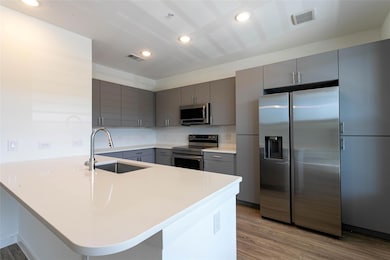 Kitchen with stainless steel appliances, gray cab