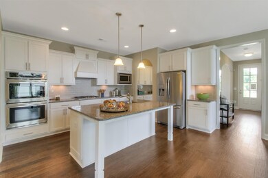 Love this Kitchen! Goodall's luxury kitchen with double ovens, gas cooktop, decorative vent hood and tall cabinets with heavy crown molding