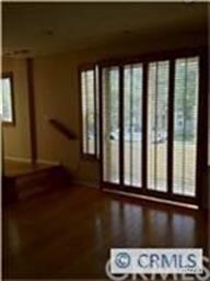 Wood floors in living room with doors to patio