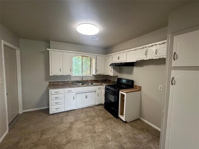 Kitchen with sink, white cabinets, black gas range