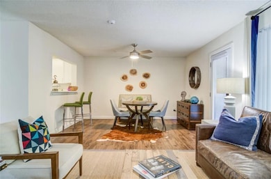 Living room with wood-type flooring, ceiling fan, 