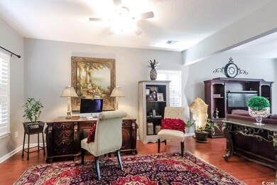 Office space with wood finished floors and a ceiling fan