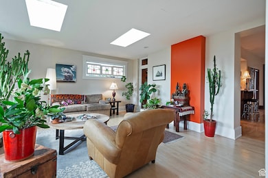 Living area with a skylight and light wood-style flooring