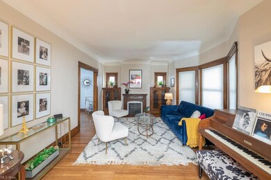 Living room with built-in leaded glass cabinets, bay window & hardwood floors