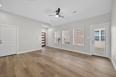 Unfurnished living room featuring healthy amount of natural light, light wood-type flooring, and a ceiling fan