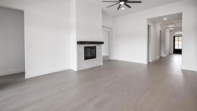Unfurnished living room featuring ceiling fan, a 