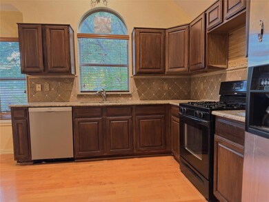 Kitchen with black gas range oven, light wood-type