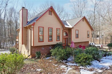 Bi-level home with a chimney, brick siding, and a 