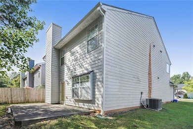 View of side of home featuring a chimney, fence, c